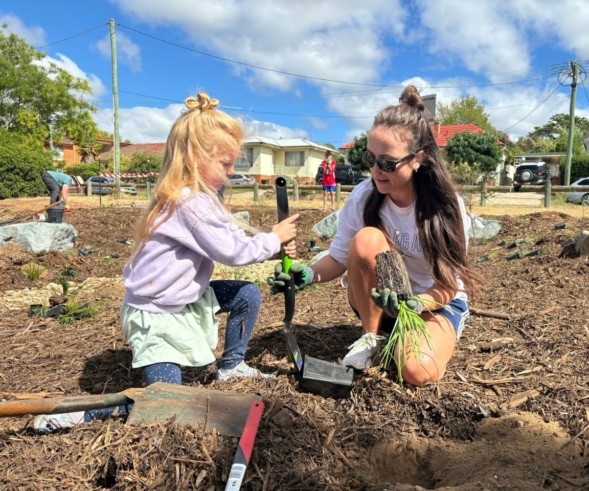 A mother and daughter planting on community planting day